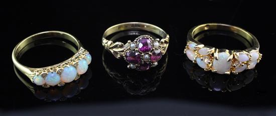 An early 20th century 18ct gold, amethyst and seed pearl cluster ring and two later gold, white opal and diamond rings,